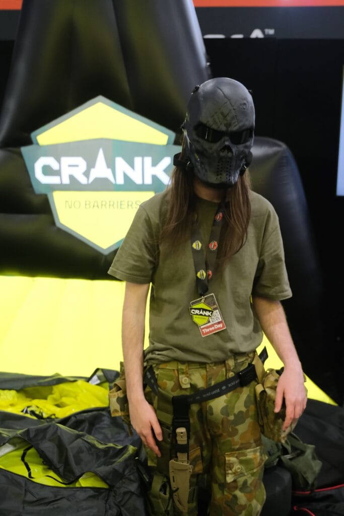 A girl in a military uniform standing next to a crank booth.
